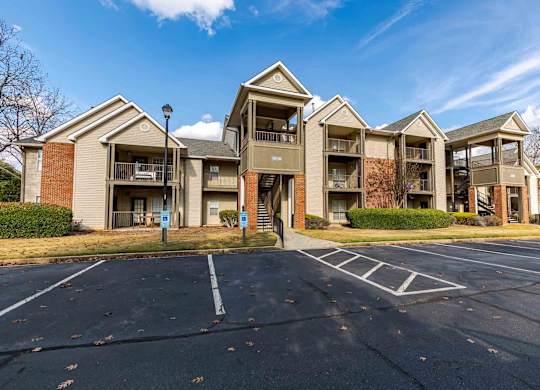 Apartment complex with a parking lot in front.