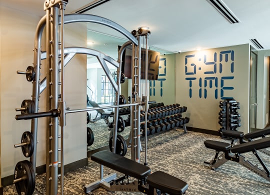 a gym with weights and cardio equipment in a hotel room at The Louis Apartment Flats, Louisville, KY