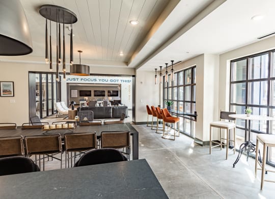 a communal area with tables and chairs and large windows at The Louis Apartment Flats, Louisville, Kentucky
