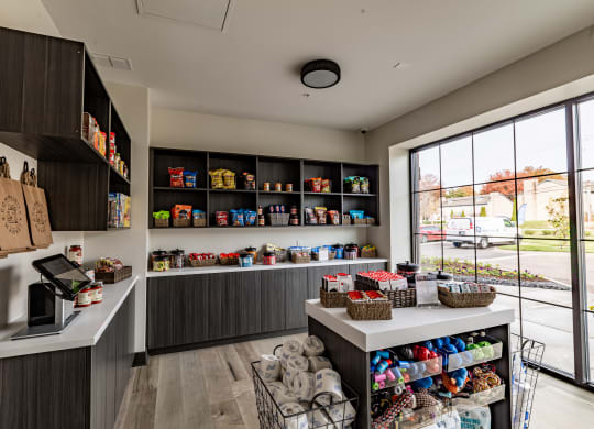 a store with a large window and a counter filled with bags and baskets of food at The Louis Apartment Flats, Louisville, 40241