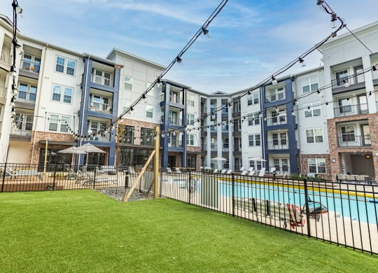 an apartment building with a swimming pool and a fenced in yard at The Louis Apartment Flats, Kentucky, 40241