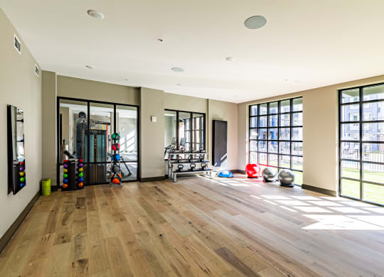 a workout room with a wood floor and large windows at The Louis Apartment Flats, Louisville, KY, 40241