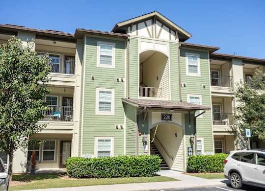 A green apartment building with the number 220 on the front door.