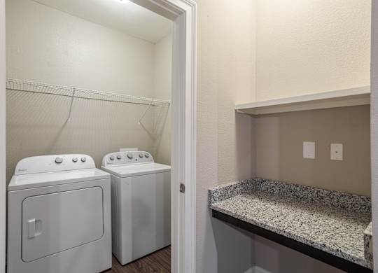 Two white front loading washing machines in a laundry room.