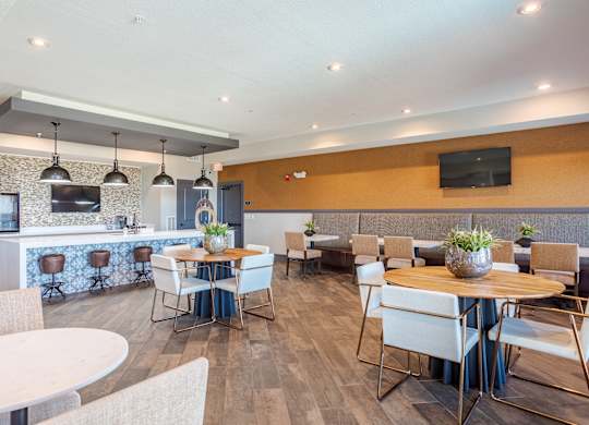 A modern dining room with a bar area and a television mounted on the wall.