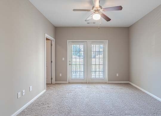 A room with a ceiling fan and a carpeted floor.