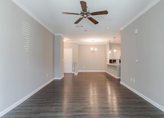 A long, empty hallway with a ceiling fan and lights.