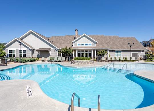 A large swimming pool in front of a house.