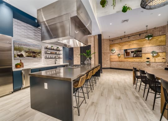 a kitchen with stainless steel appliances and a long island with chairs