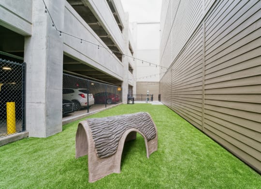 a wooden bench in the grass next to a building