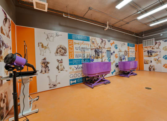 a large room with a mural of dogs on the wall and two purple baths in