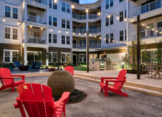 a courtyard with red chairs in front of an apartment building