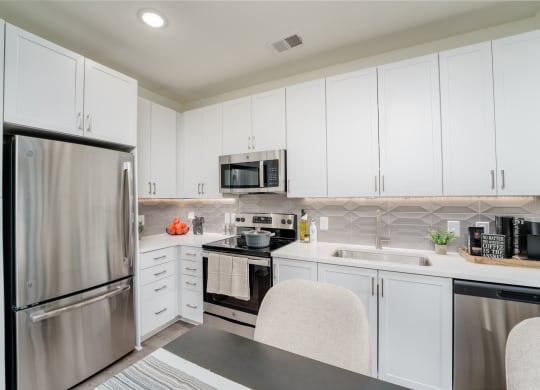 a kitchen with white cabinets and stainless steel appliances