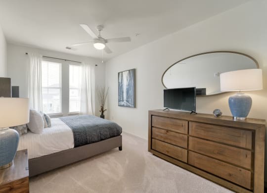 a bedroom with a bed and a dresser with a mirror