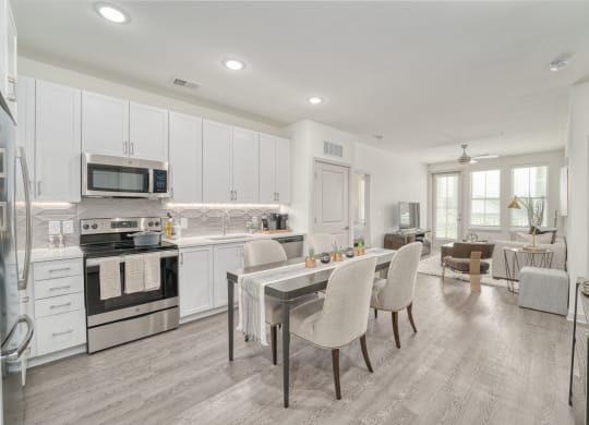 a kitchen with white cabinets and a table with chairs