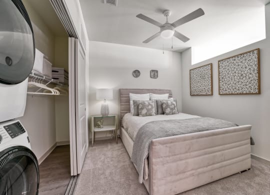 a bedroom with a bed and a washer and dryer