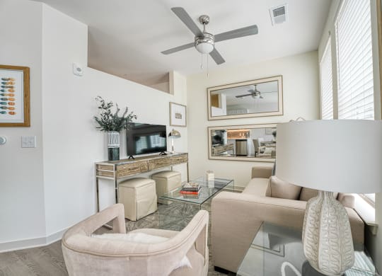 a living room with a ceiling fan and a glass table