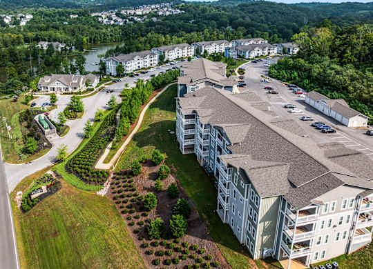 A large apartment complex with a parking lot in front.