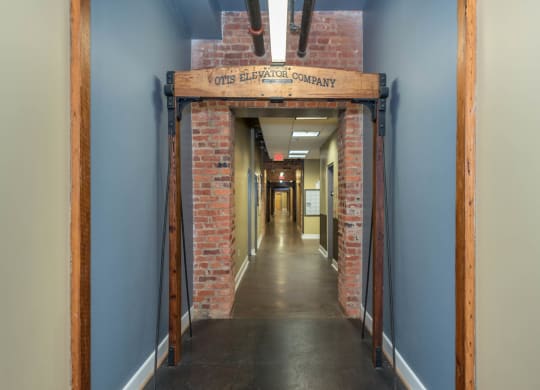 a hallway with a brick doorway with a sign above it at Mayton Transfer Lofts, Petersburg