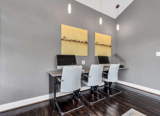 a desk with four computers in a room with gray walls and a hardwood floor at Misty Ridge Apartments, Woodbridge Virginia