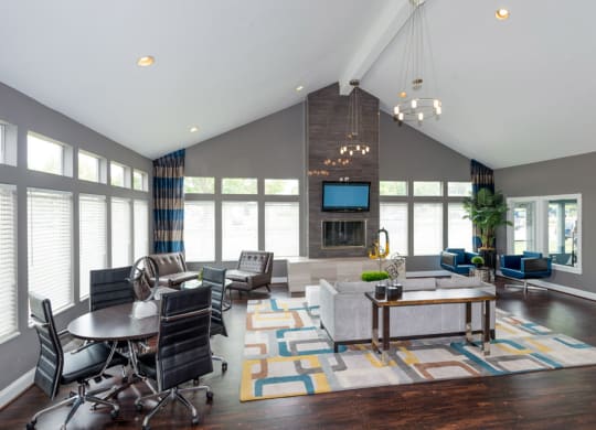 a large living room with gray walls and hardwood flooring topped by a colorful area rug at Misty Ridge Apartments, Woodbridge