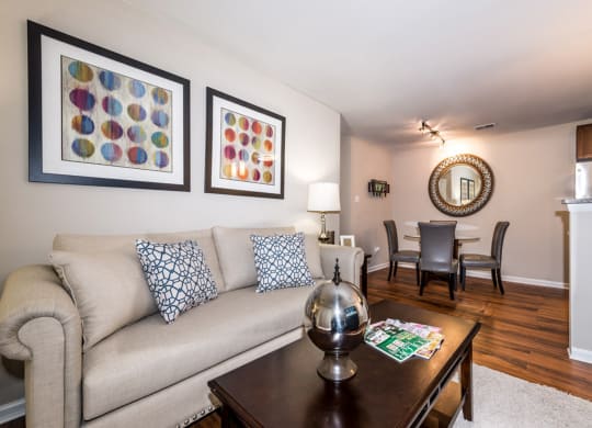 a living room with a couch coffee table and a dining room table in the background at Misty Ridge Apartments, Virginia, 22191