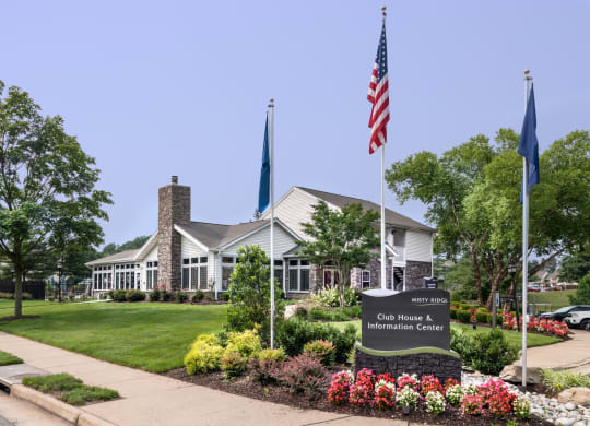 a building with an american flag and a sign in front of it at Misty Ridge Apartments, Virginia