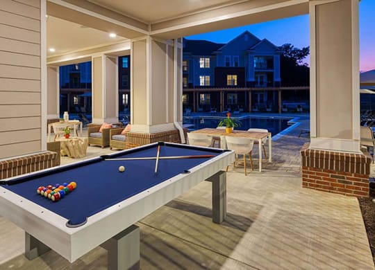 a pool table on a patio with a pool house in the background at Canopy at Ginter Park Apartments in Richmond, VA 23227