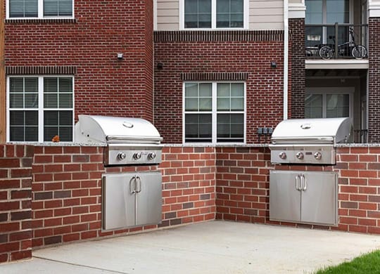 a brick wall with two grills in front of a building at Canopy at Ginter Park Apartments in VA 23227