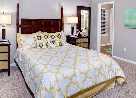 A bedroom with a bed, nightstand, and lamp at Austin Chase Apartments, Macon, 31210