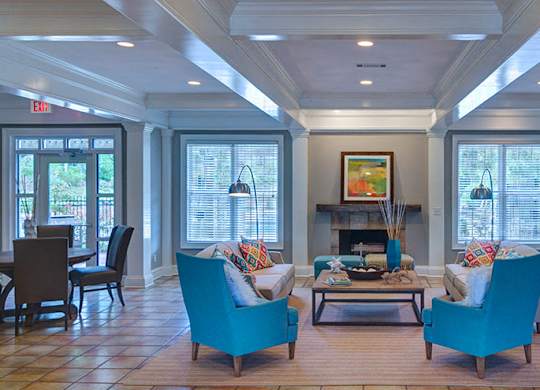 A living room with a fireplace and two chairs at Austin Chase Apartments, Georgia