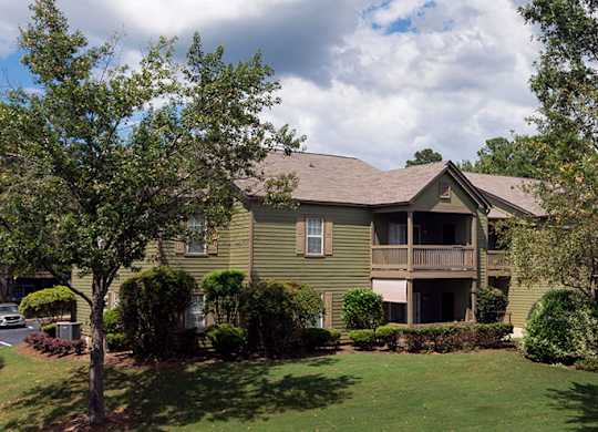 A green house with a brown roof and a balcony at Austin Chase Apartments, Macon, 31210