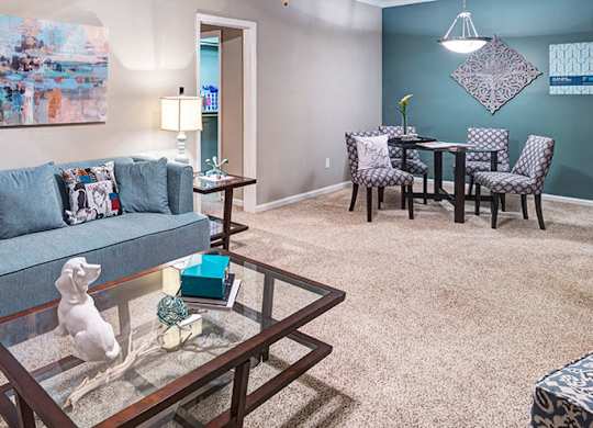 A living room with a grey couch and a glass coffee table at Austin Chase Apartments, Macon, 31210