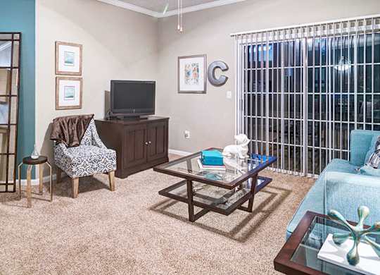 A living room with a couch, chair, and television at Austin Chase Apartments, Macon, GA