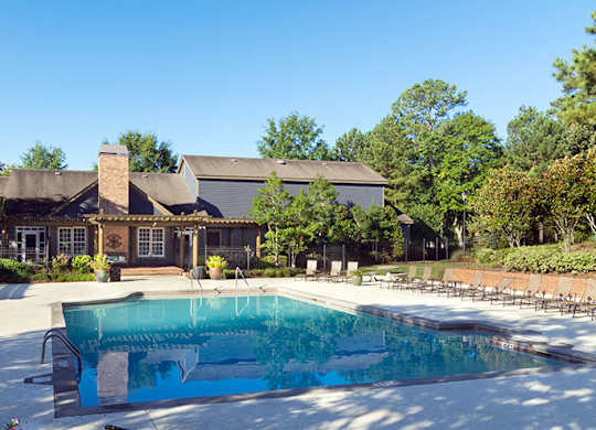 A large swimming pool with a mural on the side and a building in the background at Austin Chase Apartments, Macon