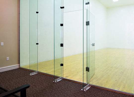 A room with a wooden floor and glass walls at Austin Chase Apartments, Georgia 31210