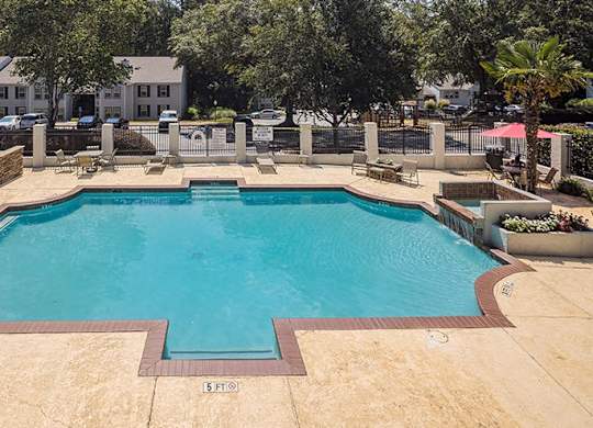 A large outdoor swimming pool surrounded by a fence.