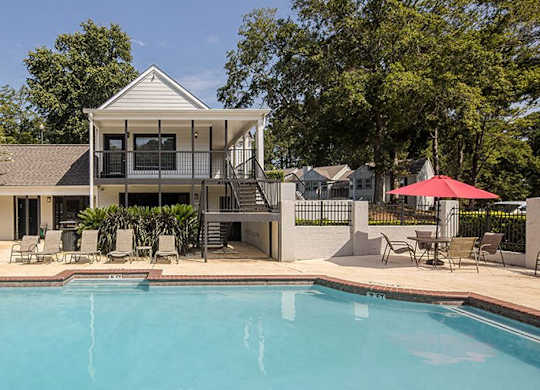 A house with a pool in front of it.