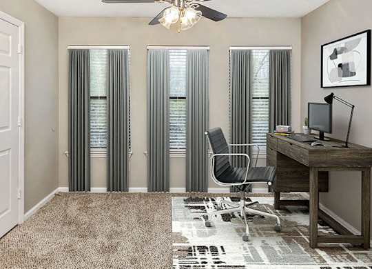 A room with a desk, chair, and a ceiling fan.
