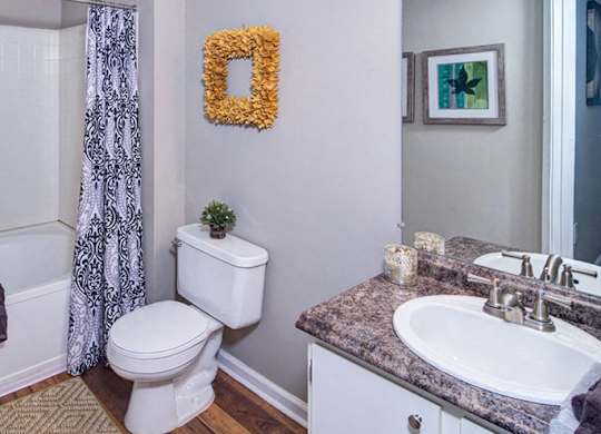 A bathroom with a toilet, sink, and shower at Huntington Chase Apartments, Georgia