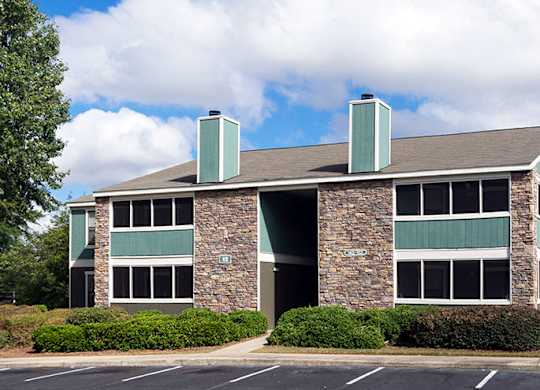 A large building with a green roof and a stone pillar in front.