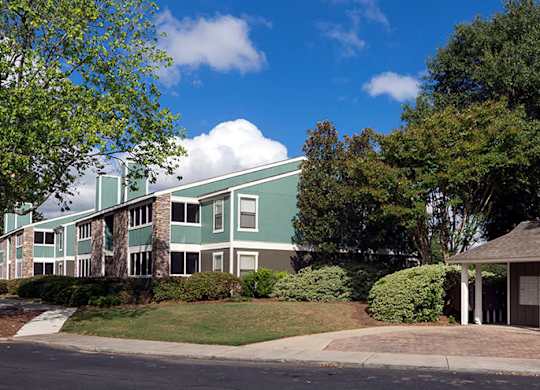 A green and white building with a gazebo-like structure in front.