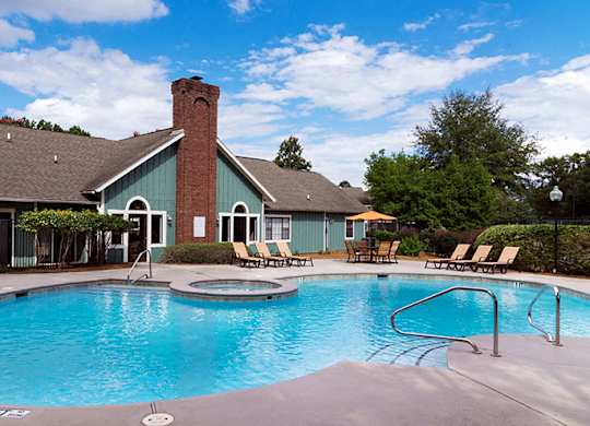 A pool with a blue water and a building beside it.