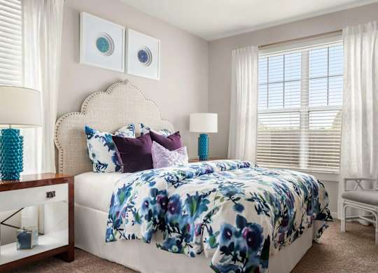 Bedroom with floral bedding and upholstered headboard at Colony at Centerpointe Apartments, Midlothian, VA 23114
