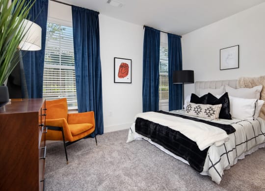 a bedroom with a bed and a desk with a chair at The Quincy Apartments, Acworth, GA, 30102