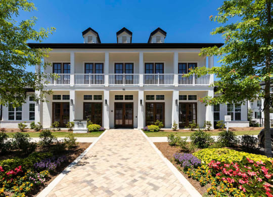 a large white house with a brick walkway in front of it at The Quincy Apartments, Acworth
