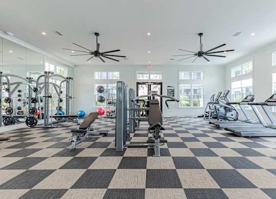 A spacious gym with a variety of equipment including treadmills, weights, and exercise machines.