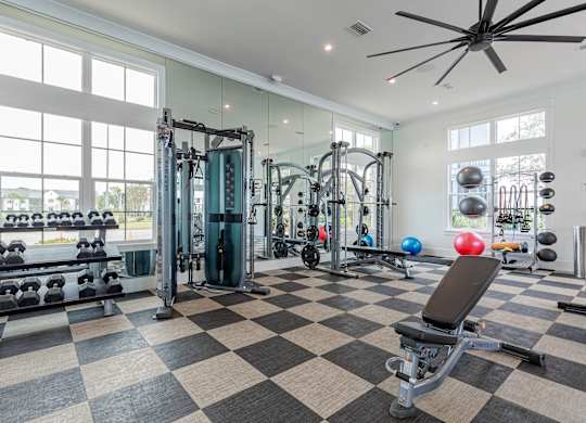 A spacious gym with a variety of equipment and a checkered floor.