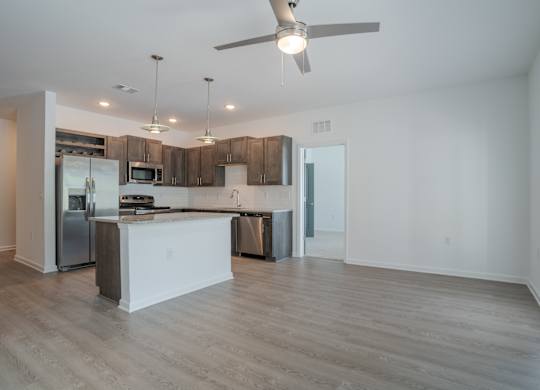 A modern kitchen with a white island and stainless steel appliances.