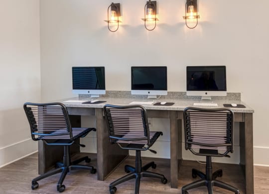 three computers on a desk in a room with three chairs at Retreat at Arden Farms, Arden North Carolina